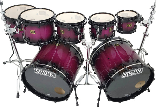 A 7-piece drum kit by SPAUN with a glossy dark purple to black gradient finish, mounted on a silver chrome hardware stand against a white studio background.